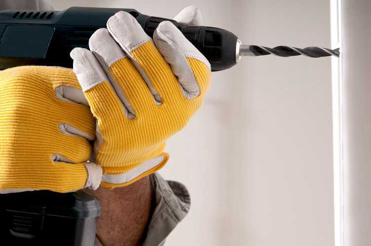Perfora los agujeros en la pared con el taladro percutor para instalar el rack de televisor